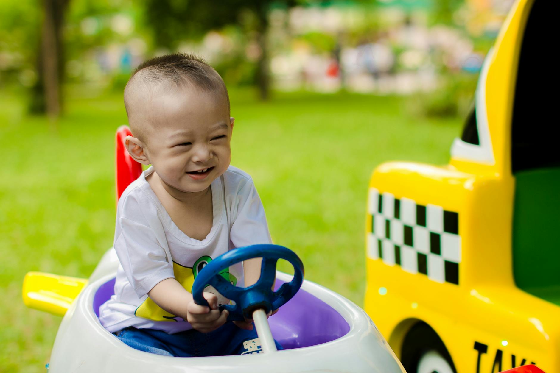 boy smiling while riding ride on toy