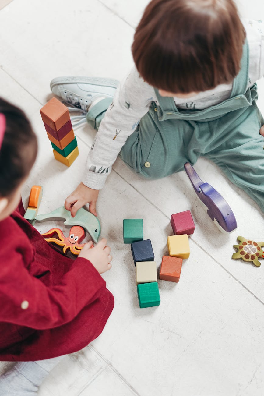 two children playing with lego blocks and other toys