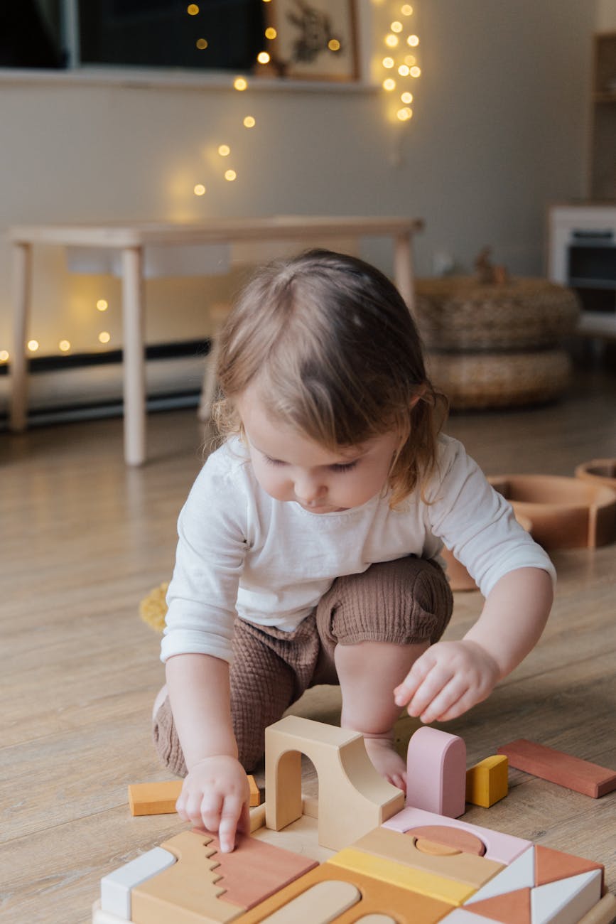 photo of child playing with wooden blocks