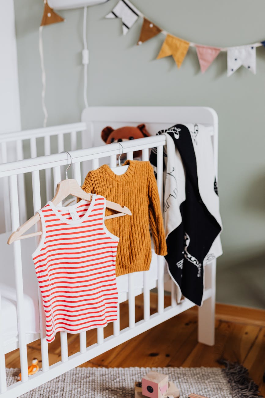 baby clothes on crib in child room